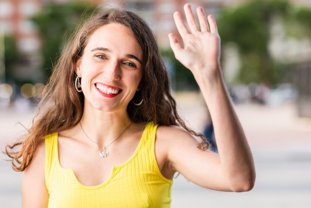 Young woman waving goodbye