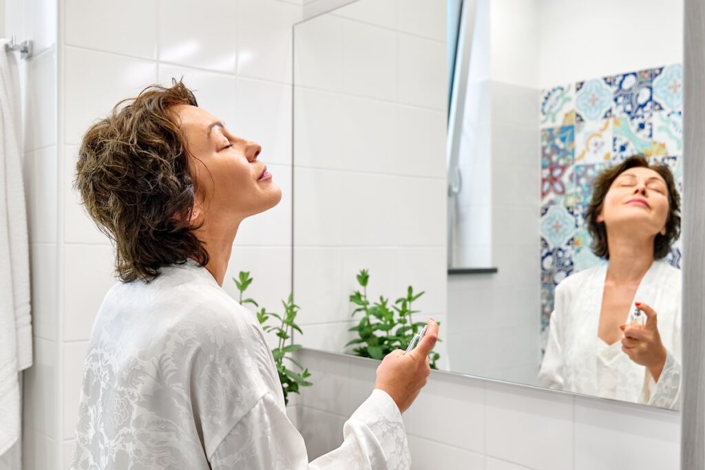 Middle aged woman looking in a bathroom mirror.