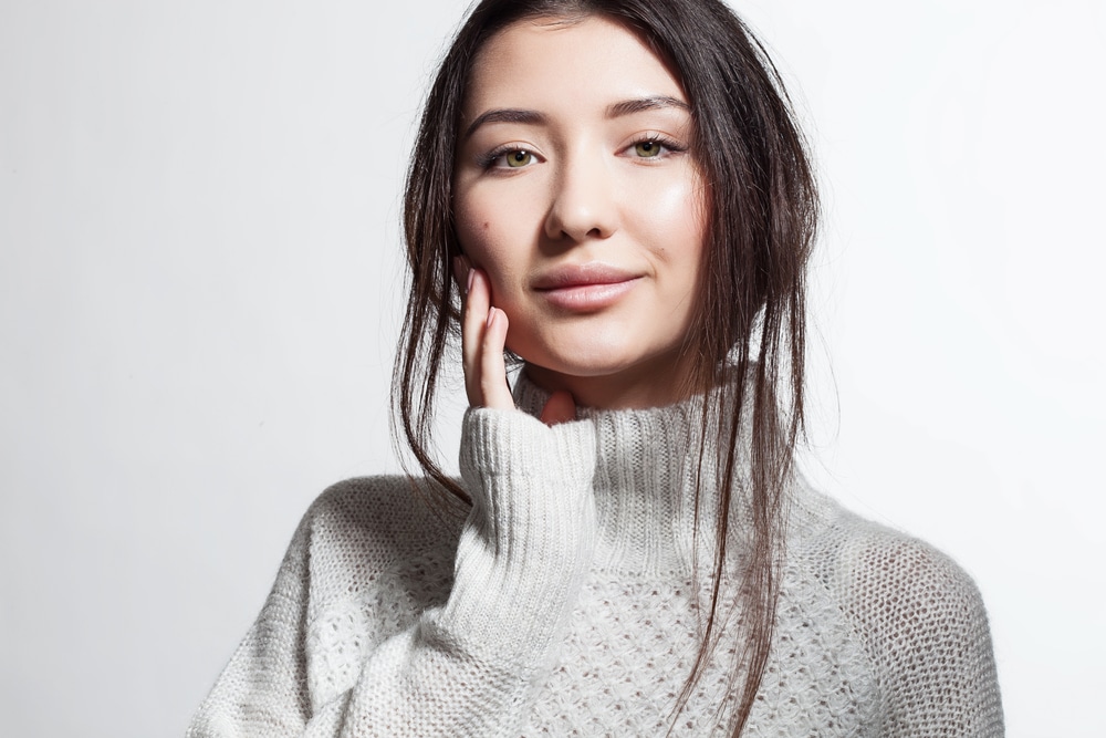 Woman in winter sweater with fresh, youthful facial skin from Softwave treatment.