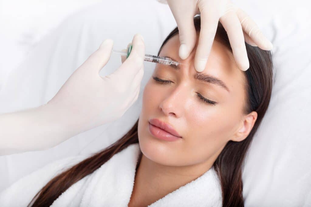 Young woman receiving Botox injections in her brow area to prevent future wrinkles