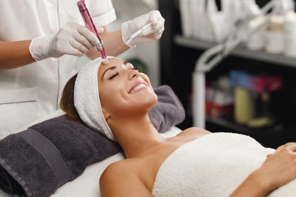 Smiling woman getting a microneedling skin tightening treatment for smoother, firmer skin